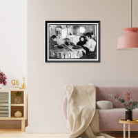Historic Framed Print, Late at night. Sewing tapes on gloves. The boy helps. Family of five sleep in room where the work is done. Location: New York, New York (State),  17-7/8" x 21-7/8"