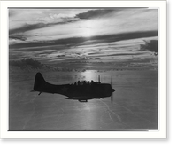 Douglas dive bomber returns to base after patrol flight as sun sets across the Pacific, Historic Print