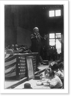One way to keep the children out of the mill. Mrs. D.E. Hudson, South Boston, Va. Her children are seated around her. In the chairs are some of her boarders. Children are well-kept. The home showed