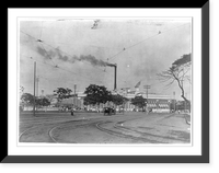 American military installations and activities in the Philippine Islands, ca. 1885 to 1925: Street scene, showing people, carriages and a rather large building, with a smoke stack smoking Timeles