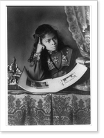 African American girl, half-length portrait, with right hand to cheek, with illustrated book on table, Antique Wall Art