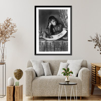 African American girl, half-length portrait, with right hand to cheek, with illustrated book on table, Antique Wall Art