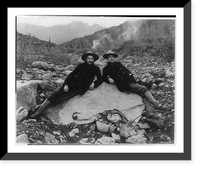 Two men recining on a large nugget of pure native copper in the bed of Nugget Creek, Valdez vicinity, Alaska Classic, Historic Reproduction