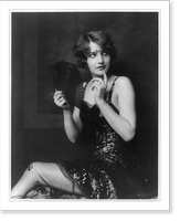 Barbara Stanwyck, three-quarter length portrait, seated, turned to the left, holding fan, Historic Reproduction