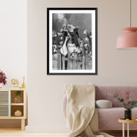 Historic Framed Print, [Girl with flowers on hat standing at gate and holding flowers],  17-7/8" x 21-7/8"
