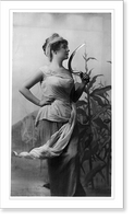 Historic Framed Print, [Young woman modeling: 3/4 lgth., standing, facing right, holding sickle; cornstalks in background],  17-7/8" x 21-7/8"