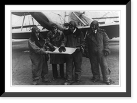 Aviators Albert Francis, A.K. Anderson, Lt. Ben H. Wyatt and R.J. Caster looking at map alongside airplane, the Shenandoah, at the Naval Air Station in Washington before leaving for Seattle Class