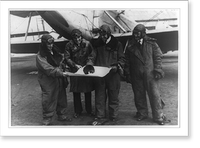 Aviators Albert Francis, A.K. Anderson, Lt. Ben H. Wyatt and R.J. Caster looking at map alongside airplane, the Shenandoah, at the Naval Air Station in Washington before leaving for Seattle Class