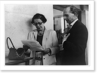 Hannah Arendt, half-length portrait, standing, facing left; looking at paper with reporter, Vintage Poster