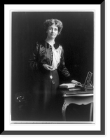 Emmeline (Goulden) Pankhurst, three-quarter length portrait, standing by small table, facing right, with left hand on book, Vintage Print