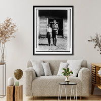 Historic Framed Print, [Charles Lindbergh and Anne Morrow Lindbergh, full-length portrait, standing in front of cabin on Etarofu Island, Russia],  17-7/8" x 21-7/8"