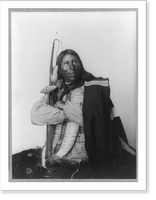 Distributor, Native American man, three-quarter length portrait, seated, facing right; arms folded, holding bow, arrow, and tomahawk; dressed in bone breast plate, Antique Wall Art