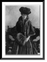 Miss A. L. Ide, three-quarter-length portrait, standing, facing right, wearing fur coat, plumed hat and muff, Historic Print