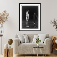 Historic Framed Print, [Gene Tunney, full-length portrait, standing, right profile, lifting weights on pulleys],  17-7/8" x 21-7/8"