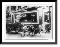 Chinese men pulling cart in a city in China with billboard advertisement for Keds shoes in rear, Historic Print
