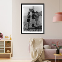 Historic Framed Print, [Mack Sennett comedy films. glamour pose by young woman in bathing suit on beach blowing into meter measuring her breath and man standing alongside],  17-7/8" x 21-7/8"