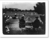 Calvin Coolidge seated on bench at right, rear view, with two other people watching baseball game, Historic Print
