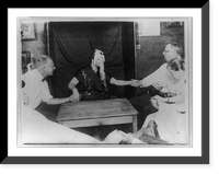 Woman medium with ectoplasm" all over her face, holding hands with two men and others at table during a seance(?)", Historic Print