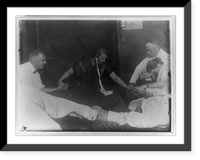 Woman medium with ectoplasm" hanging from her ear and five other people holding hands around table during seance(?)" Classic, Vintage Print