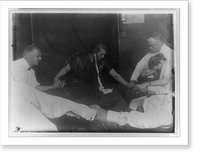 Woman medium with ectoplasm" hanging from her ear and five other people holding hands around table during seance(?)" Classic, Vintage Print