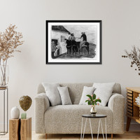 Two people on horseback, possibly Colombian, in front of house with family and dog in doorway Classic, Vintage Print