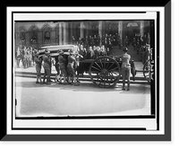 Soldiers loading flag-draped casket of former New York City mayor John Purroy Mitchel onto wagon, with Theodore Roosevelt and other officials holding their hats in respect Vintage Wall Art Print
