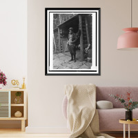 William Brewster, full-length portrait, standing, facing left, holding shotgun outside of cabin, Vintage Poster