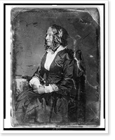 Unidentified woman, about 65 years of age, three-quarter length portrait, nearly profile to the left, seated in chair by table, hands in lap, wearing cap and light gloves Classic