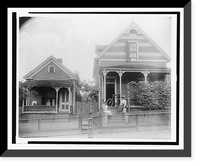 African American boy seated on porch of house, another African American boy standing with bicycle on porch of another house, with two young African American women on steps, Georgia Heritage Wall