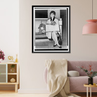 Audrey Hepburn, full-length portrait, seated at Idlewild Airport, facing left, holding her dog, Assam, Vintage Wall Art