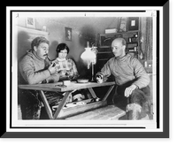 Rockwell Kent, seated at table at his home in Greenland, with his Eskimo housekeeper and her husband, Historic Reproduction