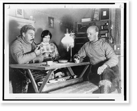 Rockwell Kent, seated at table at his home in Greenland, with his Eskimo housekeeper and her husband, Historic Reproduction