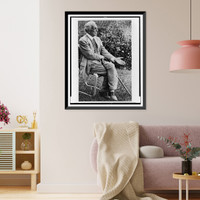 Frank Lloyd Wright, full-length portrait, seated in chair outdoors, facing right, left hand extended palm up, Vintage Print