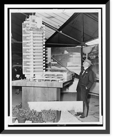 Frank Lloyd Wright, full-length portrait, standing, facing left with cane raised to a model of Price Tower, Oklahoma Classic, Historic Reproduction