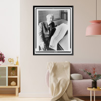 Frank Lloyd Wright, three-quarter length portrait, seated, facing front, holding sketch of a 528 story office building he designed, Antique Poster