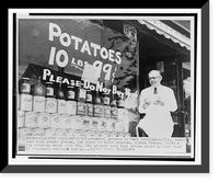 Grocer Alfred Freese Port Washington, Wis., holds potatoes in front of sign painted on store window encouraging customer not to purchase potatoes, Vintage Poster