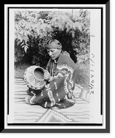 San Ildefonso Pueblo man Julian Martinez, seated on et, facing left holding pottery, Vintage Poster