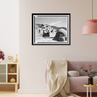 Taos man holding his granddaughter, facing right with adobe oven on right, and Taos Pueblo in background, Vintage Print