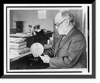 Dr. J. Walter Fewkes, seated at desk, facing left, examining disk showing figure entering maze - 2, Vintage Print