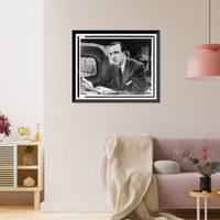 Historic Framed Print, [Walter Cronkite, half-length portrait, facing left, seated at desk with notes in hand and television monitor showing his image for The Morning Show"",  17-7/8" x 21-7/8"