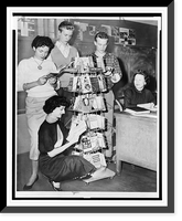 Connie Masi, Sheila Macy (kneeling), Ernest Sims, and Fred Kimtscher students at William Cullen Bryant High School gather around mobile shelving in the library.World Telegram & Sun photo by Herma