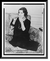Romola Najinsky, full-length portrait, seated on sofa, facing left, lighting cigarette, Antique Poster