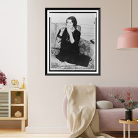 Romola Najinsky, full-length portrait, seated on sofa, facing left, lighting cigarette, Antique Poster