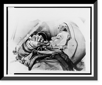 Historic Framed Print, [Valentina Tereshkova, head-and-shoulders portrait, left profile, wearing space helmet and suit, eating from a food tube during training],  17-7/8" x 21-7/8"