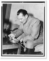 Hermann G&ouml;ring, three-quarter length portrait, seated on bed(?), facing left, eating from pan.U.S. Army Signal Corps, Vintage Poster
