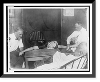 Woman medium lying on table, with ectoplasm on her head, surrounded by four other people, during seance, Vintage Print