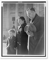 Photograph shows a man, woman, and child with down-cast eyes, and the man has removed his hat, Historic Print