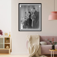 Photograph shows a man, woman, and child with down-cast eyes, and the man has removed his hat, Historic Print