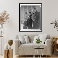 Photograph shows a man, woman, and child with down-cast eyes, and the man has removed his hat, Historic Print