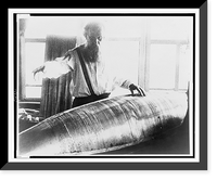 Konstantin Tsiolkovsky, half-length portrait, facing front, looking down at model of an early Russian rocket, Historic Print